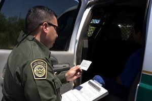 A U.S. Customs and Border Protection (CBP) Border Patrol agent reading the Miranda rights to a suspect