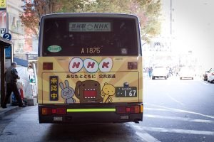 Domo (middle) and friends on a bus advertisement for NHK